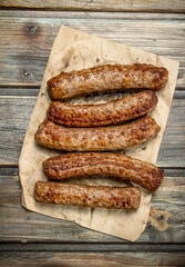 Grill sausages on paper .