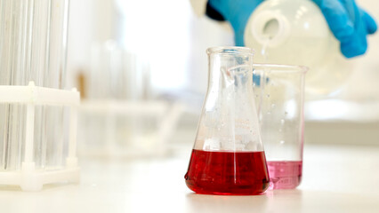in the laboratory, a laboratory assistant conducts chemical experiments