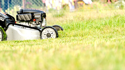 Lawn mover on green grass in modern garden. Machine for cutting lawns.