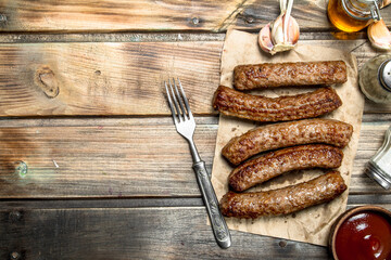 Grilled beef sausage with tomato sauce .