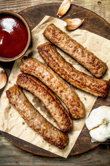 Grilled beef sausage with tomato sauce .