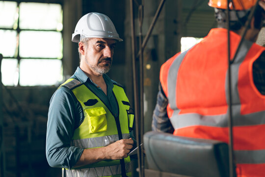men at work concept, confident engineer person man occupation or professional manufacturing technician foreman portrait with industry safety helmet, inspector job manager to work in factory warehouse