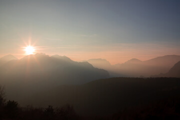 landscape with the silhouettes of the mountains seen in the foggy morning