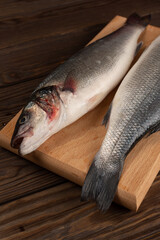 Two fresh sea bass fish on a cutting board