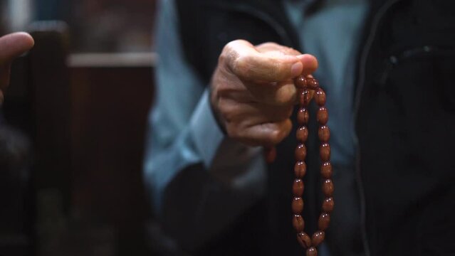 Man counting the prayer beads on his prayer beads in his hand aka tesbih 