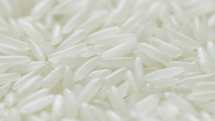 Close up of uncooked white rice falling.