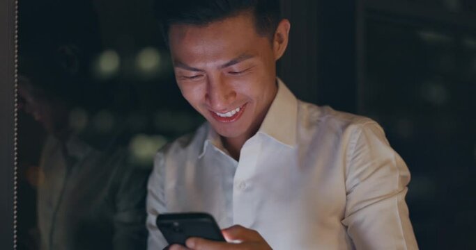 Smartphone, night and business man networking on global app, happy notification or social media chat. Smile of corporate, asian worker using phone or cellphone in dark office on digital communication