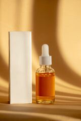 Glass bottle with moisturizing serum without marking with white dropper lid and packing box on...