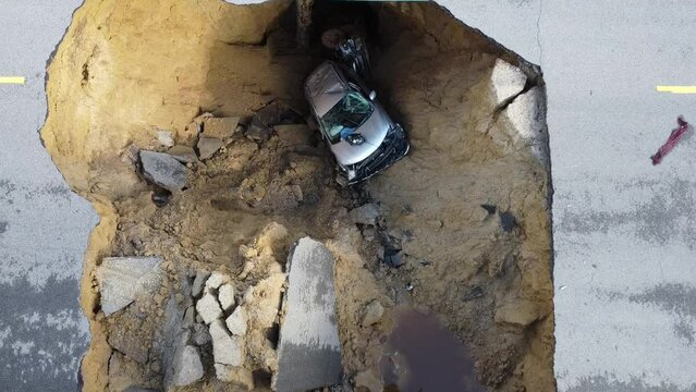 Large Sinkhole swallows cars on busy street