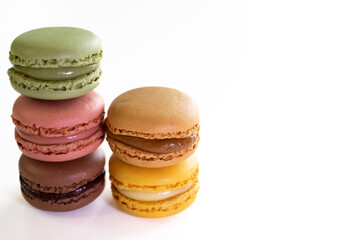 Close-up of macaroons cakes of different pastel colors in white background. Culinary and cooking concept. Tasty colourful macarons. Copy space for text or message