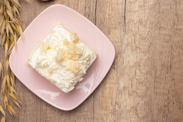 Sliced delicious vanilla cake on wooden background