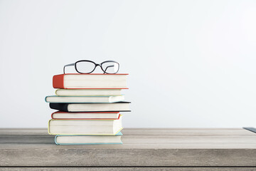 Education, personal development and study concept with eyeglasses on stack of books on wooden table surface and white wall background. 3D rendering