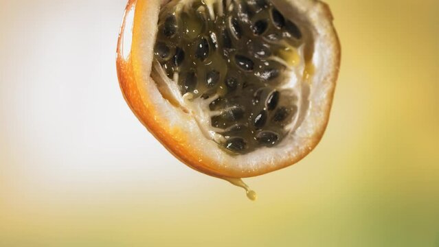 Slow Motion Macro Shot of Flowing Granadilla Juice from Halved Granadilla