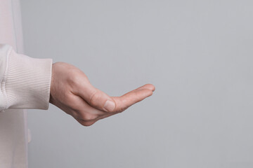 Female health. Man holding her hand on grey background, closeup with space for text