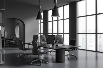 Corner view on dark office room interior with computers, desks