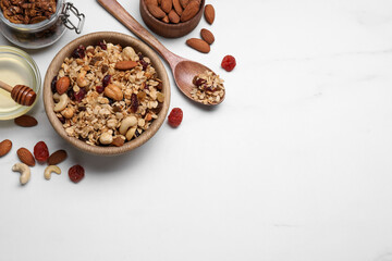 Obraz na płótnie Canvas Tasty granola served with nuts and dry fruits on white marble table, flat lay. Space for text