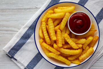 Homemade Unhealthy Crinkle French Fries with Ketchup on a Plate, top view. Flat lay, overhead, from above. Copy space.