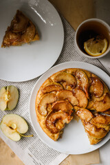 piece of homemade apple pie on a white plate, apple pie in section,sweet homemade cake for tea,  quarters of a fresh apple, caramelized apple pie 