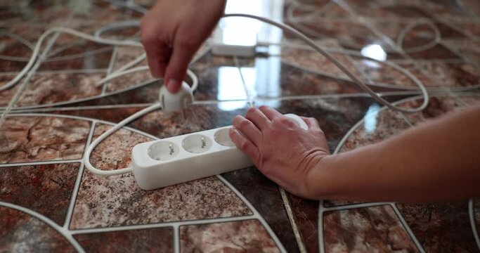 Woman hand taking out plug from electric socket with extension closeup 4k movie slow motion 