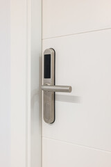 Door handle with plastic card with microchip or digital code. Closeup of an entrance white door with an electronic mortise lock.