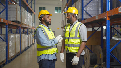 Teamwork of black workers working in large warehouse store industry.Rack of stock storage. Interior of cargo in ecommerce and logistic concept. Depot. People lifestyle. Shipment service for container