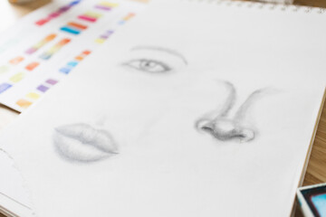 Fototapeta premium Sketch on Art Desk with Paintings and Brush Colorful Creative Creativity