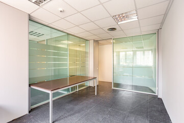 An empty room with clear, durable glass wall panels are ideal for dividing a large space into individual offices. Glass panels are the best solution for decorating any office space.