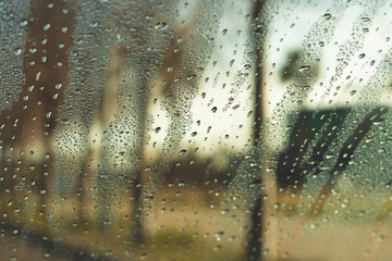  Through window of car with raindrops on glass of street on gloomy autumn day 