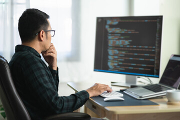 Software develper asian man wearing glasses working coding Write a program develope AI application...