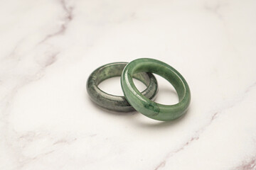 Green jade rings on a marble table