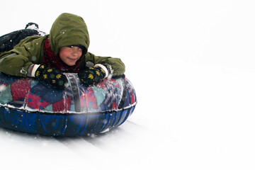 Winter Games. A child rides a tubing down the mountain. Kids are playing.