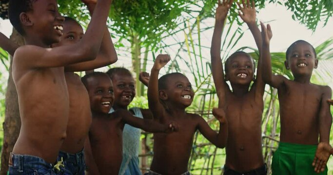 A Group Of African Children, Laughing, Jumping And Playing in Rural Area. Black Kids Celebrating Life with Joy. Camera Captures Beauty and Essence Of Childhood, Innocence and Purity of Live in Village