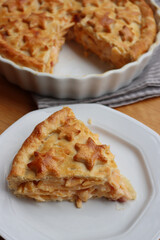 Cut Italian Timballo or Timbale filled with pasta and bechamel with tomato sauce on wooden table