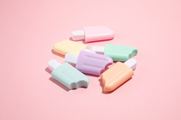 Ice cream toys made from plastic on pink background with copy space