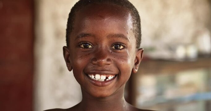 Portrait of a Smiling African Kid in a Rural Area Laughing and Looking at the Camera. Little Face Full Of Joy and Life After Having Fun Playing with Water and Getting Refreshed in Summer Hot Weather