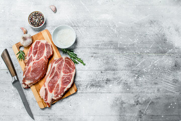 Raw pork steaks with salt and spices.
