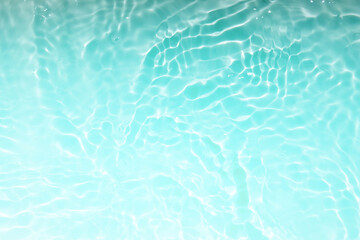 Defocus blurred transparent blue colored clear calm water surface texture with splashes and...