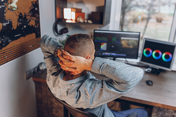 High angle of relaxed male freelancer resting after finishing work on computer in video editing...
