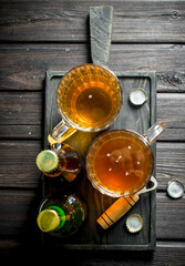 Beer in mugs and bottles with opener on the cutting Board.
