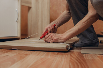 Crop man unpacking cardboard box in room at home  