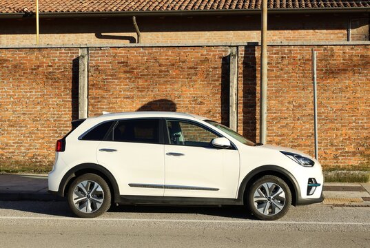 Udine, Italy. January 14, 2023. White Kia Niro, subcompact crossover suv of the south korean automaker, on brick wall background. Side view