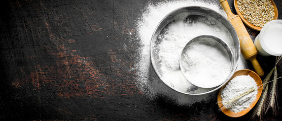 Fototapeta na wymiar Flour with a sieve, rolling pin and grain.