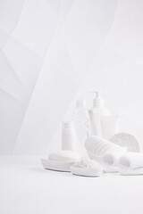 Modern minimalist soft light white bathroom with cosmetic product and toiletry - towels, bath salt,...