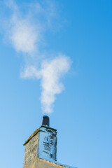 Smoke from a domestic property against a blue sky