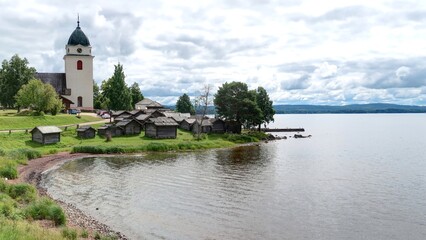 Fototapeta na wymiar sur les bords du lac Siljan en Suède, église de Rättvik et maisons anciennes en bois
