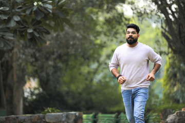 Young indian man running at park