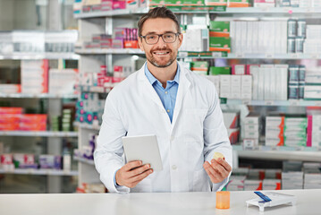 Portrait, tablet and healthcare with a pharmacist man at work in a pharmacy for pharmaceutical medication. Medicine, trust and pills with a male working in a medical dispensary for treatment or cure