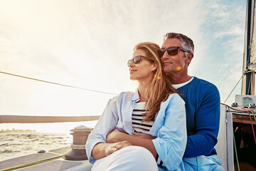 Yacht, travel and love with a mature couple sitting together on a boat out at sea for a romantic date. Luxury, ocean or summer with a married man and woman on a ship to relax during a trip - Powered by Adobe