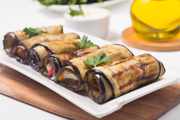 Baked grilled eggplant rolls with cottage cheese, tomatoes and sour cream. Georgian cuisine. 