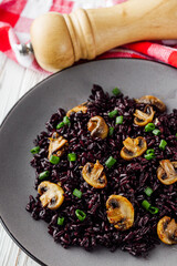 delicious black rice with mushrooms on a white background